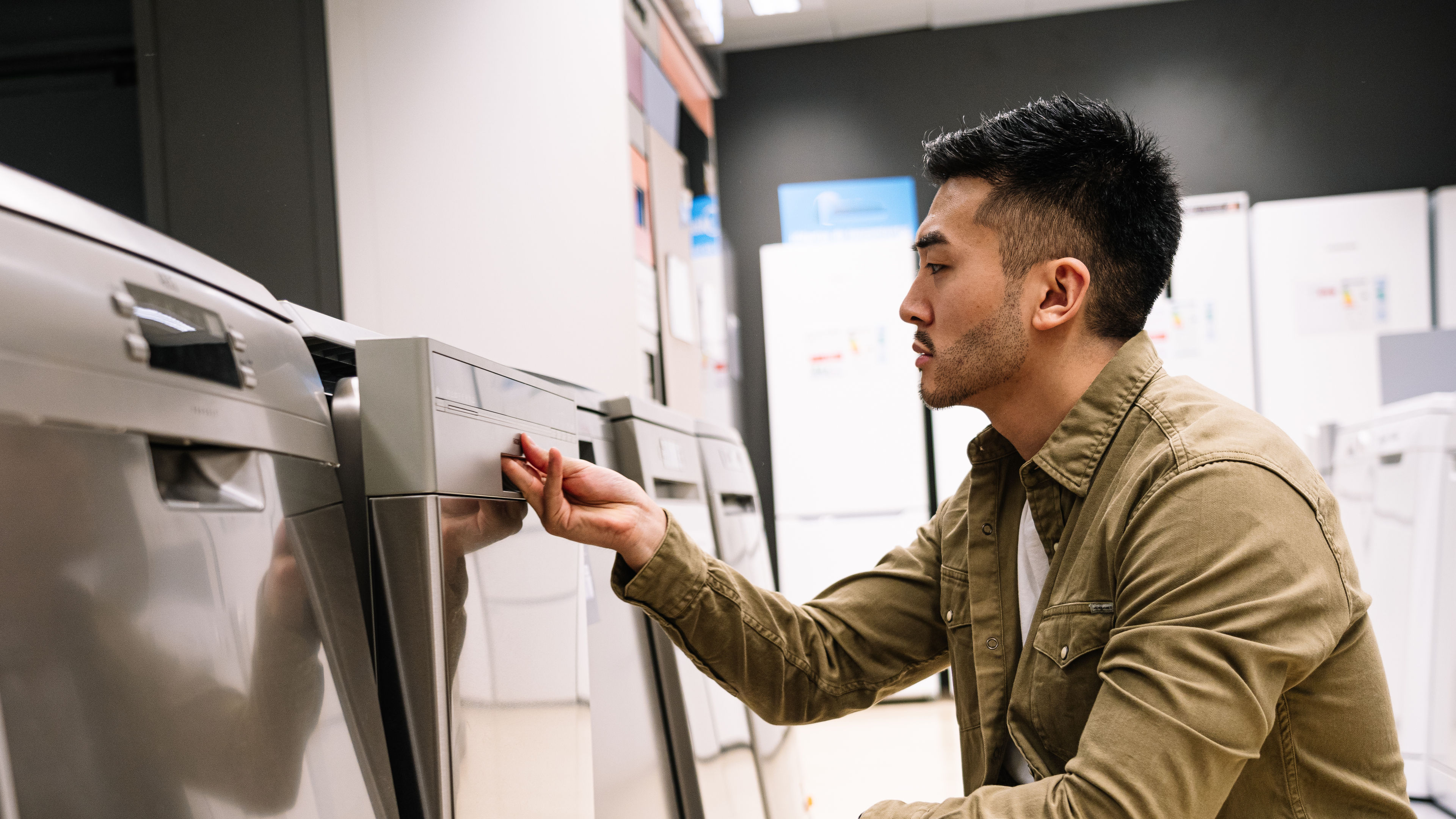 Man Examining New Appliances in Retail Store
