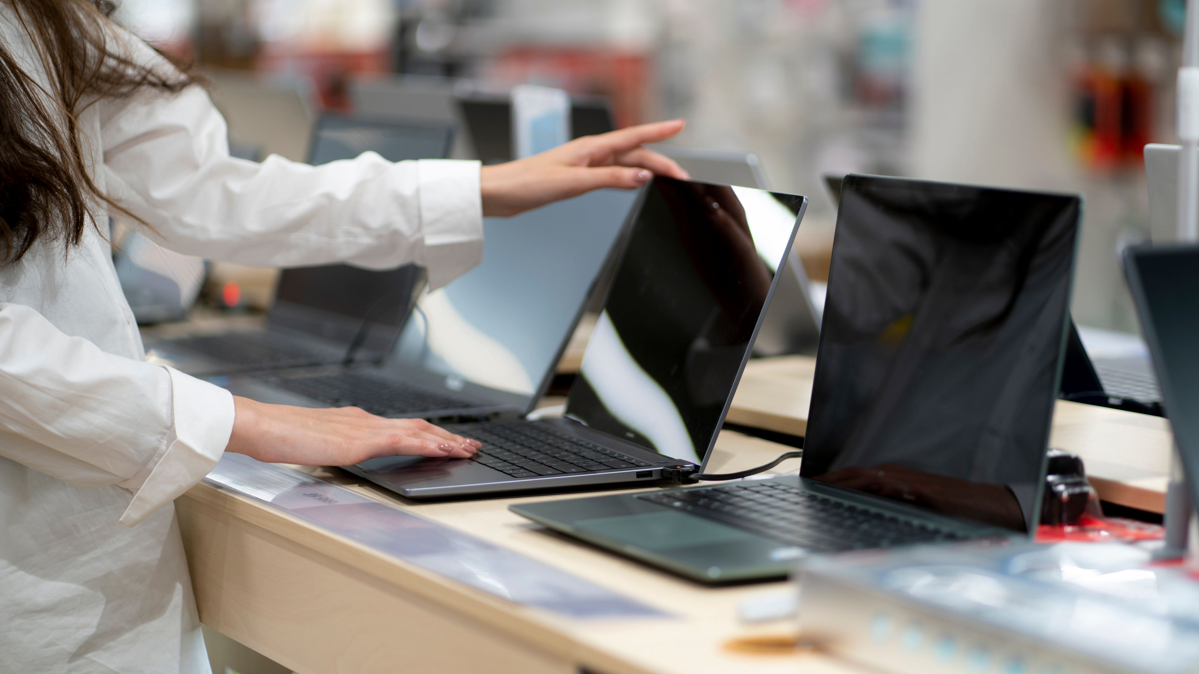 Woman shopping for laptops in an electronics store