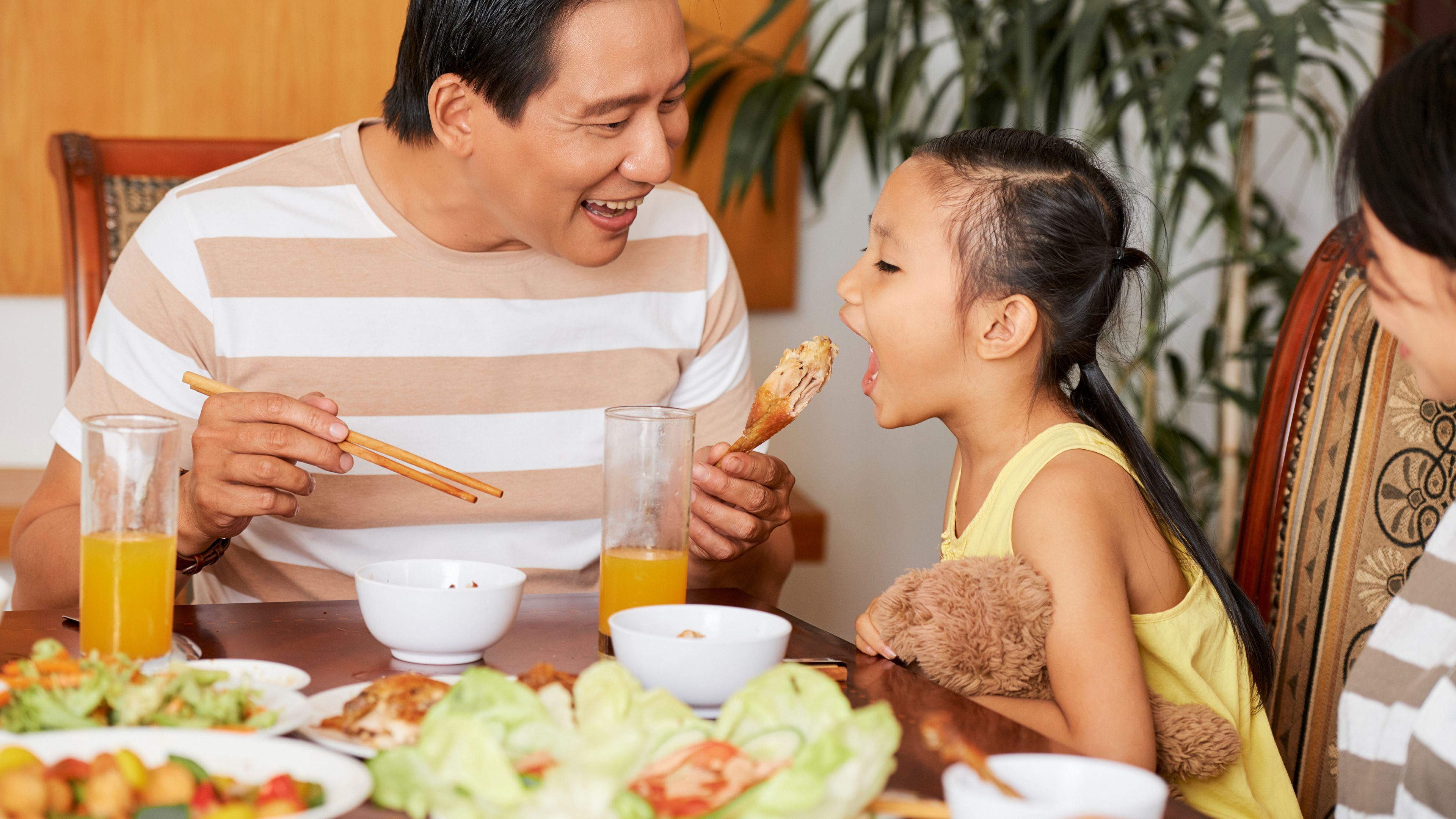 A father giving food to his daughter