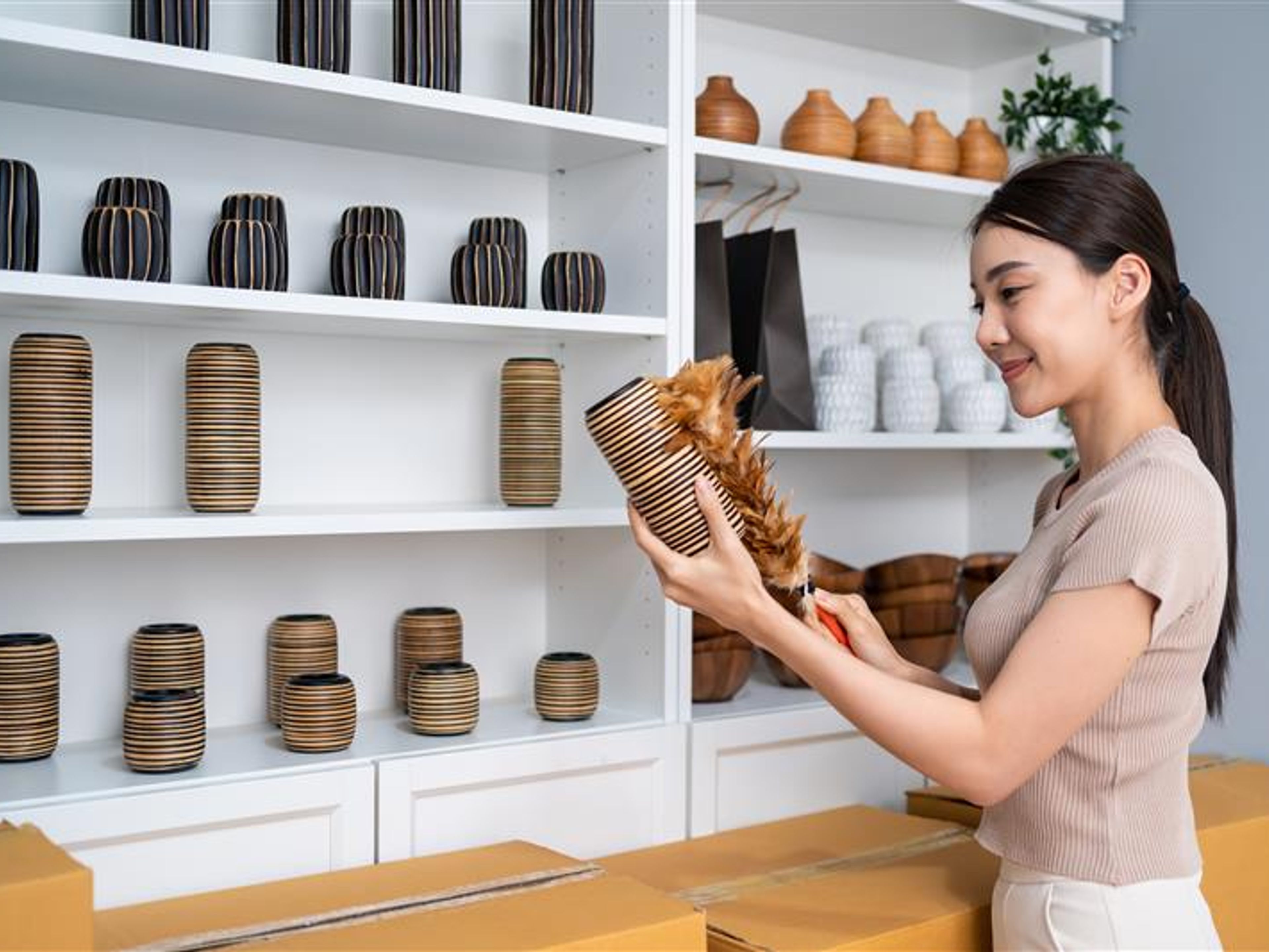 A woman holding a vase in hand
