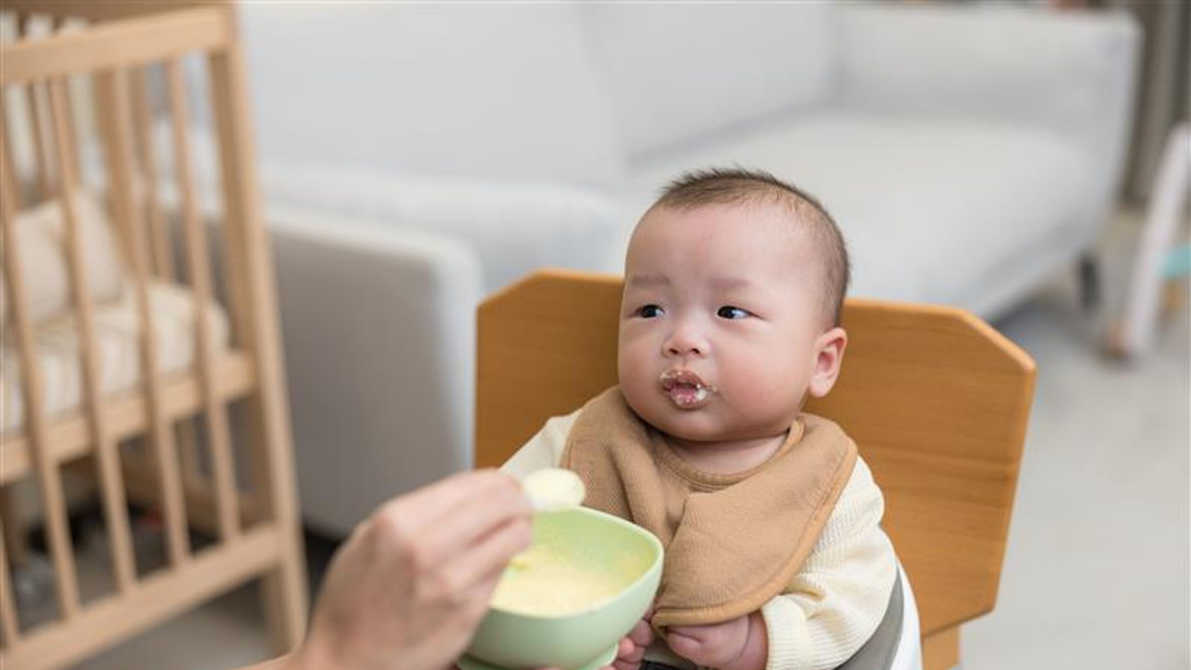 Baby eating food on high chair