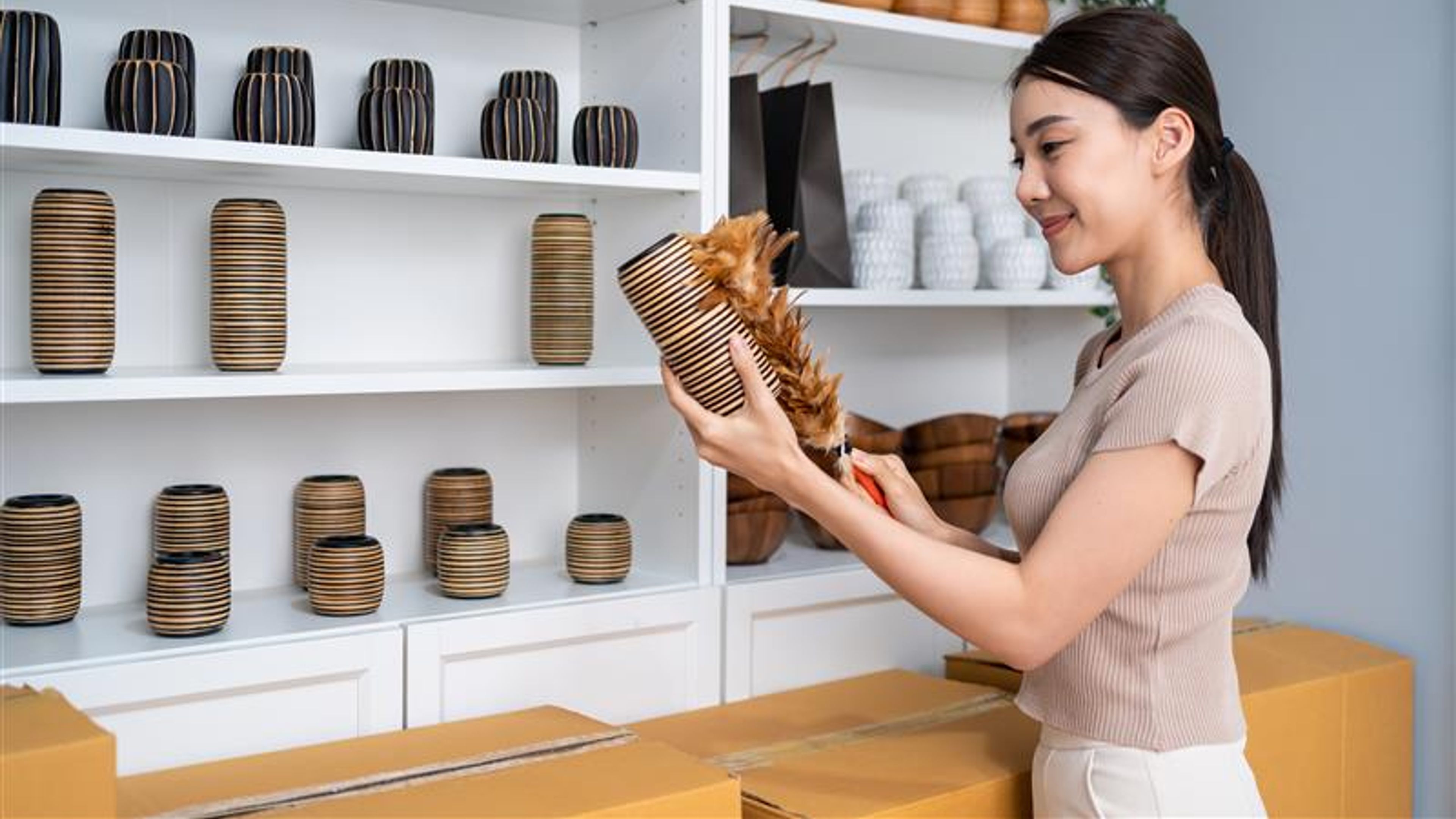 A woman holding a vase in hand