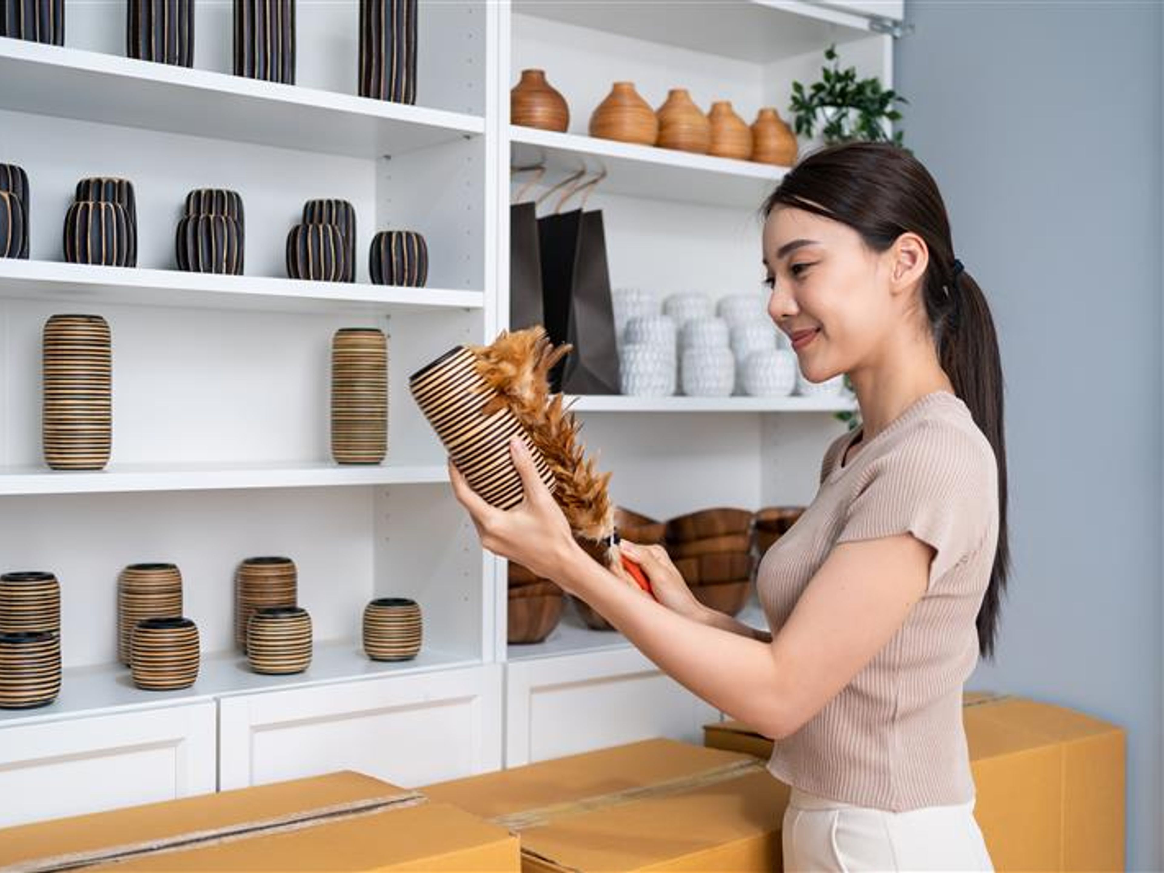 A woman holding a vase in hand