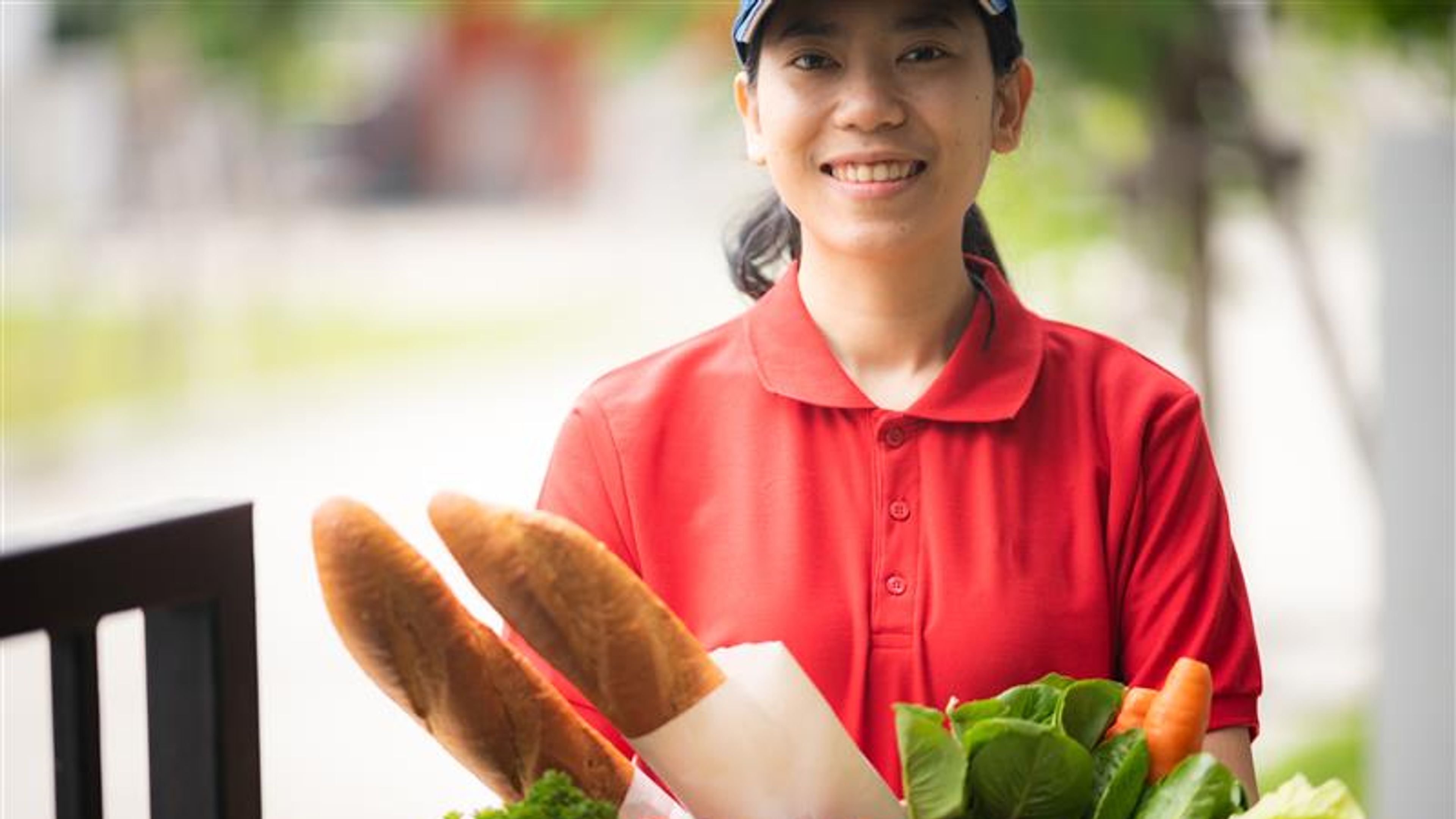Food delivery service women smiling and happy to work to deliver fresh healthy food to customers at home.